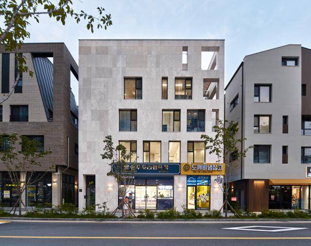 건물의 북측, 도로에서 바라본 정면 모습. '라임스톤'으로 마감한 묵직한 건물 외관에 다양한 직사각형 창문이 들어가 생동감을 살렸다. 김용수 건축사진작가 제공