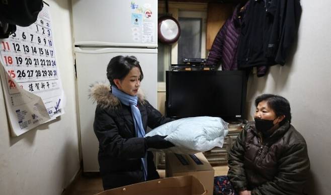 윤석열 대통령 부인 김건희 여사(왼쪽)가 22일 ‘찾아가는 성탄절 희망 박스 나눔’ 행사를 위해 서울 용산구 남대문 쪽방촌을 찾아 주민에게 겨울 점퍼를 선물하고 있다. 대통령실 제공