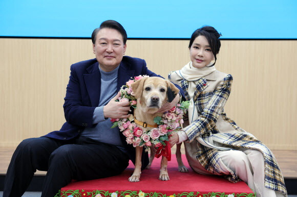 윤석열 대통령과 김건희 여사가 24일 경기도 용인 삼성화재 안내견 학교에서 분양받은 은퇴 안내견 새롬이와 기념사진을 찍고 있다. 대통령실 제공