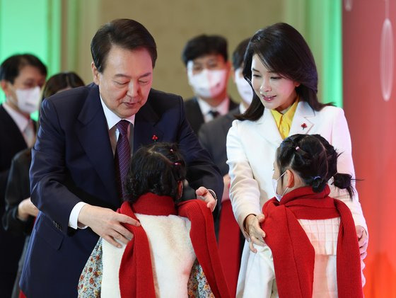 윤석열 대통령과 김건희 여사가 23일 청와대 영빈관에서 열린 보호아동·자립준비청년과 함께하는 크리스마스 행사에서 아이들에게 목도리를 걸어주고 있다. 사진 대통령실