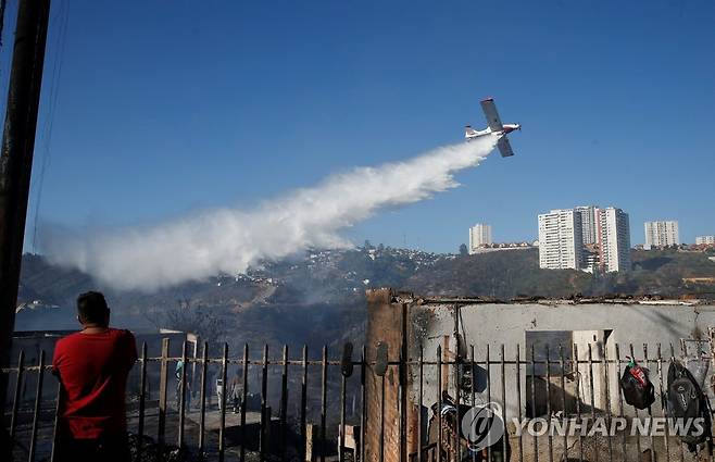 항공기로 진화 작업 안간힘 (비냐델마르[칠레] 로이터=연합뉴스) 23일(현지시간) 칠레 비냐델마르에서 소방당국이 화재 진화를 위해 항공기로 물을 뿌리고 있다. 2022.12.24