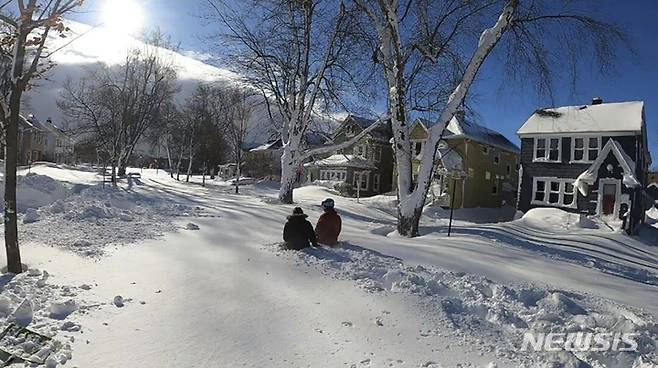 [뉴욕=AP/뉴시스] 많은 눈이 내린 25일(현지시간) 미국 뉴욕 버팔로에서 주민들이 이동하고 있다. 2022.12.26.