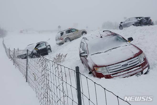 [미시간=AP/뉴시스] 23일(현지시간) 미국 미시간 바이런 센터 인근 도로에 세워진 차량들이 눈에 파묻혀 있다. 2022.12.26.