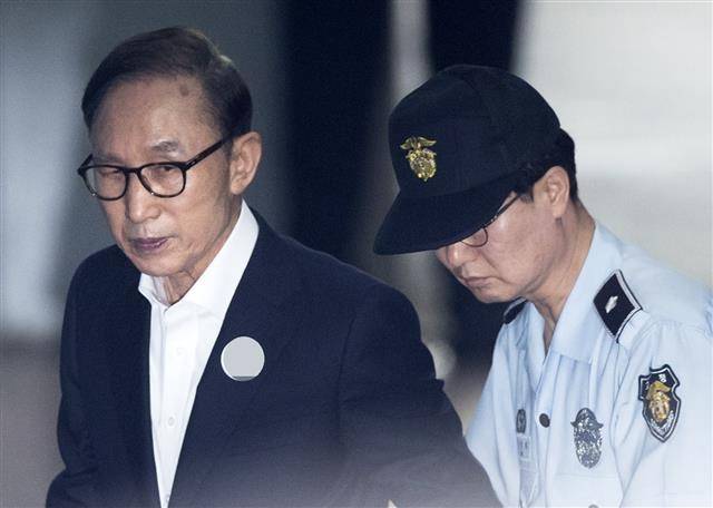 이명박 전 대통령이 2018년 6월 4일 서울 서초구 서울지방법원의 공판에 출석하기 위해 호송차에서 내려서 걷고 있다. 연합뉴스