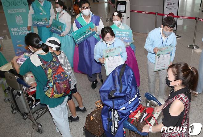 부산관광공사 직원들과 한국방문위원회 직원들이 8월16일 부산 강서구 김해국제공항 국제선청사에서 정부의 특별시행에 따라 무비자 입국이 허용된 일본인 관광객들을 맞이하고 있다. 2022.8.16/뉴스1 ⓒ News1 김영훈 기자