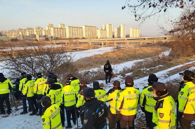 지난 27일 오후 경기 파주시의 한 강가에서 경찰이 살해당한 50대 여성의 시신을 찾기 위해 수색 중이다. ⓒ연합뉴스