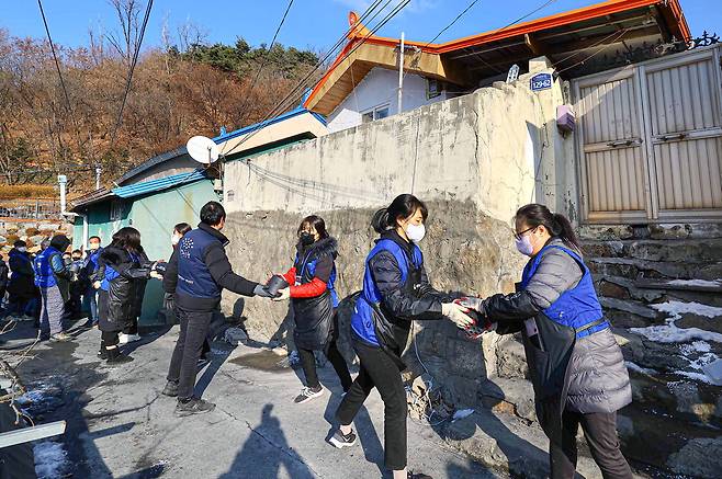 29일 서울 서대문구 홍제동 개미마을에서 행복공감봉사단원들이 사랑의 연탄 배달 봉사활동을 하고 있다.  <이충우 기자>