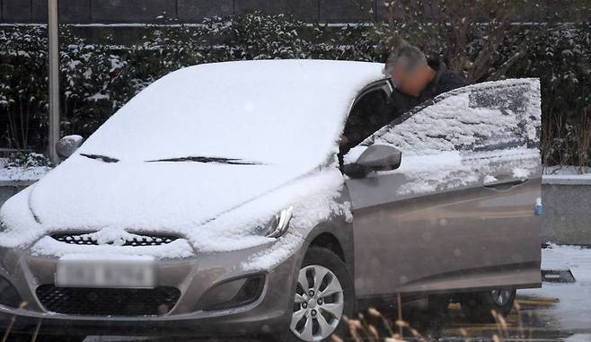 [전주=뉴시스] 김얼 기자 = 쌀쌀한 겨울 날씨가 이어지고 있는 22일 전북 전주시 완산구 중앙동에서 한 시민이 눈이 쌓인 차량에 탑승하고 있다. 2022.12.22.