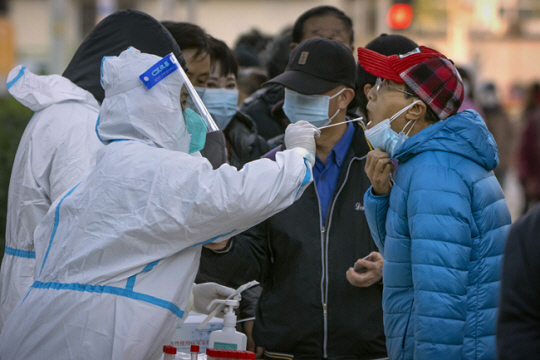 지난 11월 15일 중국 베이징의 코로나19 검사장에서 마스크를 쓴 사람들이 검사를 받고 있다. AP·뉴시스