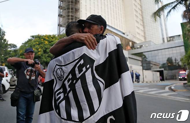 29일(현지시간) 브라질 상파울루에서 브라질 '축구 황제' 펠레의 사망 소식이 알려지자 펠레가 입원한 종합병원 앞에서 대기하던 축구 팬들이 서로를 끌어 안으며 애통하고 있다. 알베르트 아인슈타인 병원은 이날 성명을 통해 펠레가 다발성 장기부전으로 사망했다고 발표했다. 2022.12.29. ⓒ AFP=뉴스1 ⓒ News1 김성식 기자