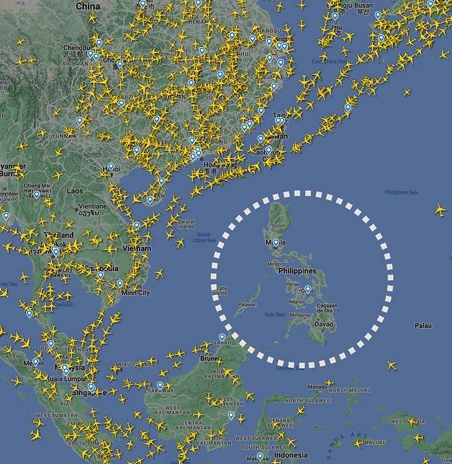 항공기 추적 사이트 'flightradar24'에 오후 2시 40분쯤 표시된 항공편들. 필리핀(흰색 원) 상공만 운항 중인 항공기가 없는 상태다. /flightradar24 캡처