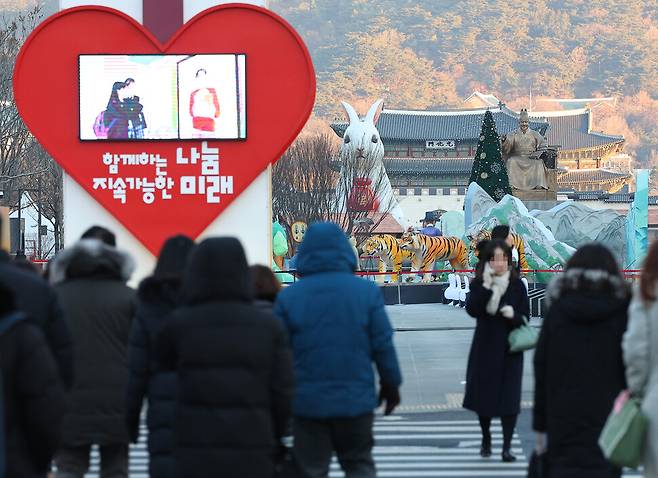 2023년의 첫 출근일인 2일 오전 서울 종로구 세종대로사거리에서 시민들이 각자 자신들의 일터로 향하고 있다. 시민들 뒤로는 토끼와 호랑이 모양의 조형물이 설치돼 있다. 2023.1.2 연합뉴스