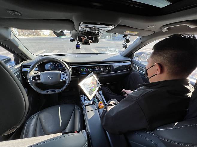 2022년 1월 2일 중국 베이징시 다싱구 이좡 ‘베이징시 고급별 자율주행 시범구(BJHAD)’에서 주행 중인 바이두의 자율주행 택시(로보택시) 앞자리의 운전석은 비어 있고 조수석에 안전요원이 앉아 있다. /김남희 특파원