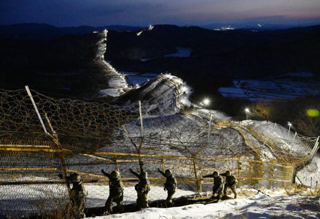 경기 연천군 육군 제5보병사단 독수리여단 GOP 부대 장병들이 이른 새벽 동이 트지 않은 어둠 속에서 DMZ 완전 경계 작전 성공을 위해 철책선을 정밀 점검하고 있다.