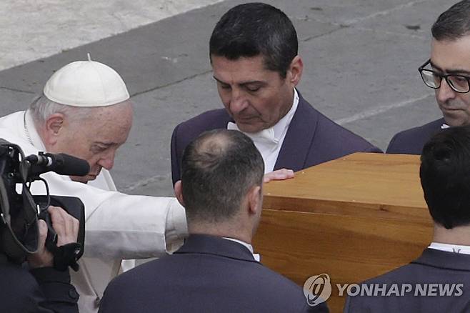 묵상하는 프란치스코 교황 (바티칸 AP=연합뉴스) 프란치스코 교황이 5일(현지시간) 바티칸 성 베드로 광장에서 거행된 장례 미사에서 베네딕토 16세 전 교황의 관에 손을 얹고 묵상하고 있다. 2023.01.05 photo@yna.co.kr