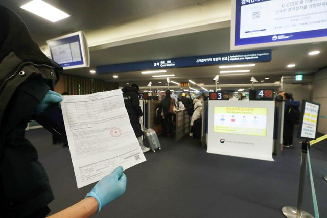 5일 오후 인천국제공항 제1여객터미널 입국장에서 한 중국인 탑승객이 코로나19 음성 확인서를 보여주고 있다. 연합뉴스