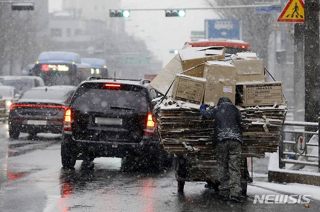 [서울=뉴시스] 고승민 기자 = 전국 강추위 속 중부지방에 대설주의보가 발효된 15일 서울 을지로에서 한 남성이 폐지 리어카를 밀며 발걸음을 옮기고 있다. (위 사진은 해당 기사내용과 무관함.) 2022.12.15. kkssmm99@newsis.com