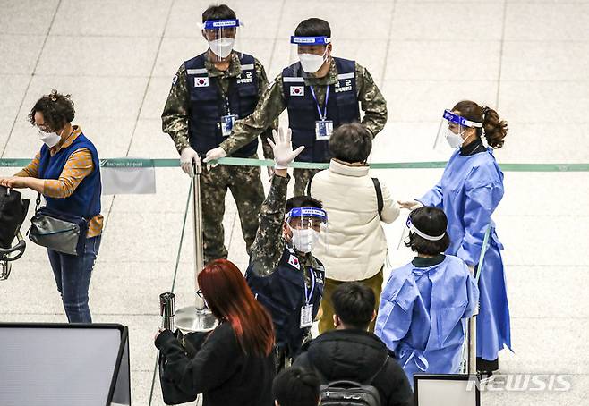 [인천공항=뉴시스] 정병혁 기자 =  중국발 입국자 코로나19 검사 의무화가 시행중인 6일 오후 인천국제공항 제2여객터미널에서 선양발 입국자들이 검역 지원 육군 장병들과 PCR검사 대기장소로 이동하고 있다. 2023.01.06. jhope@newsis.com