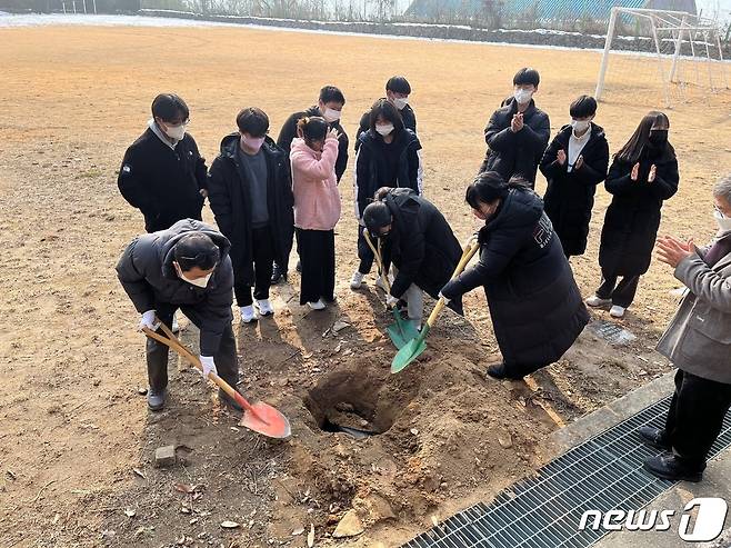 충북  영동 추풍령중학교 졸업생들이 타임캡슐을 매설하고 있다. (영동교육청 제공)