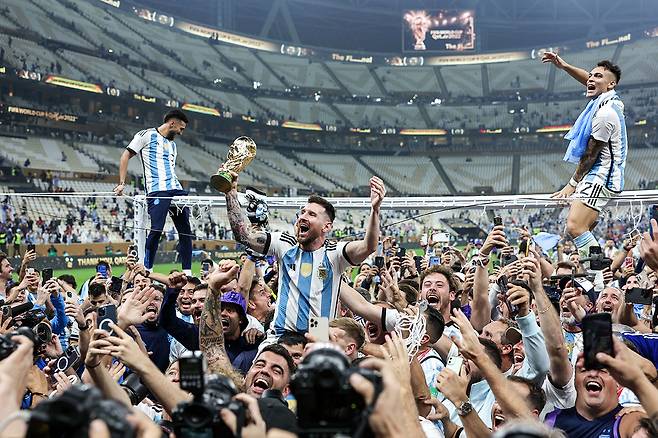 아르헨티나 축구 국가대표팀 리오넬 메시(가운데)와 팀원들이 카타르월드컵 결승전에서 프랑스를 상대로 승리를 거둔 뒤 트로피를 들고 환호하고 있다. ⓒTASS