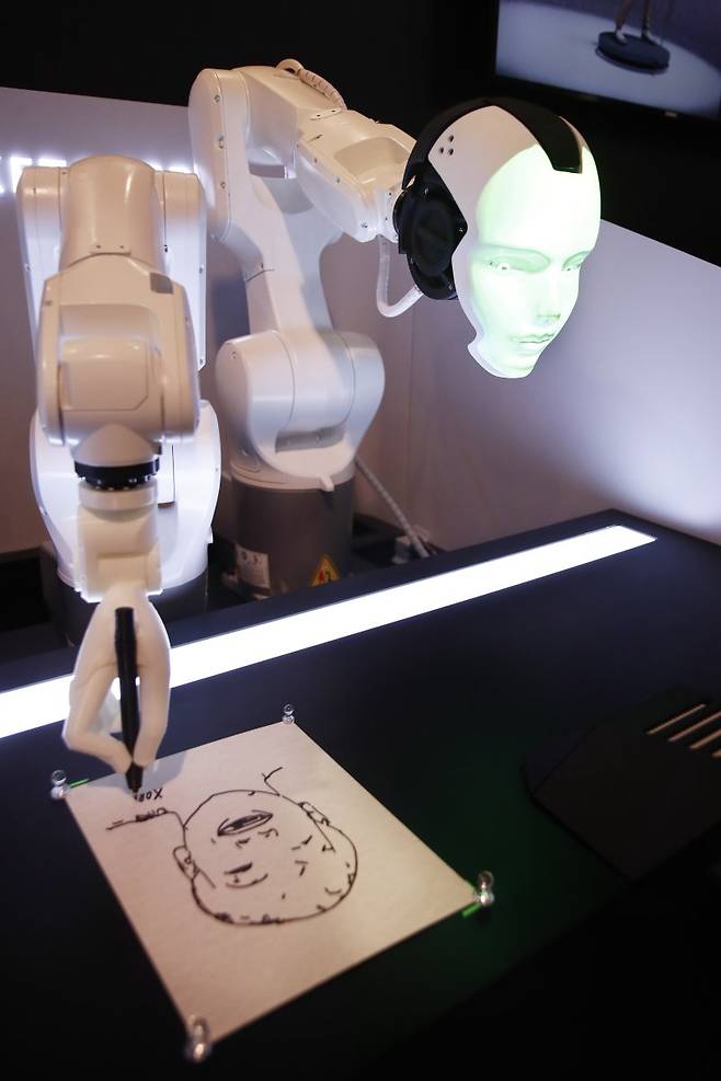 CES 2023이 열린 미국 라스베이거스에서 미국 기업 리치테크 로보틱스가 개발한 로봇 '애덤'이 커피를 만들고 있다(위쪽 사진). 아래쪽은 한국의 엑스오비스가 개발한 로봇 '스케쳐X'가 초상화를 그리는 모습 AP·EPA연합뉴스