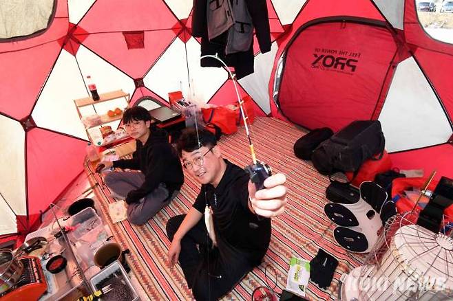 이원주 씨가 낚시 전용 텐트 안에서 아들과 빙어 낚시를 즐기고 있다. 