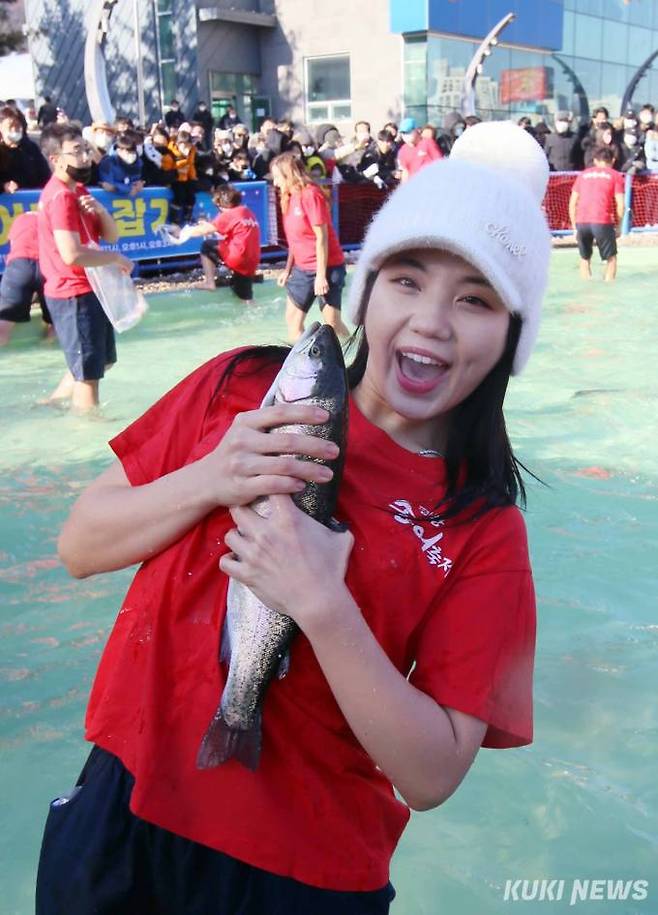 평창 송어축제장에서 맨손으로 송어를 잡은 한 체험객이 밝은 표정을 짓고 있다.