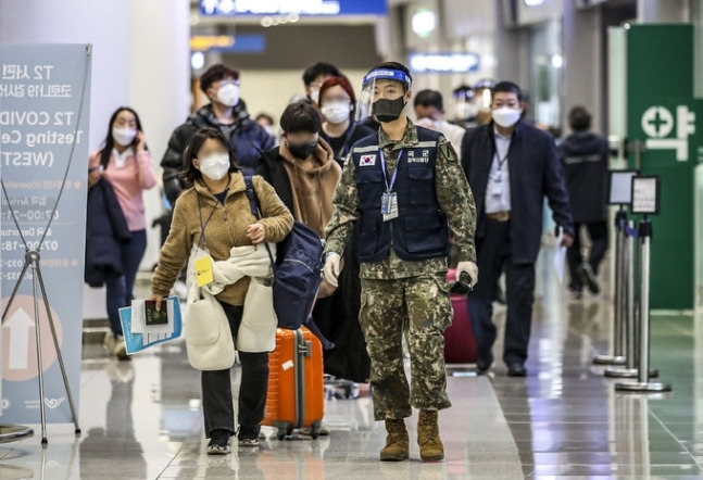 중국발 입국자 신종 코로나바이러스 감염증(코로나19) 검사 의무화가 시행 중인 6일 인천국제공항 제2여객터미널에서 선양발 입국자들이 검역 지원 육군 장병들과 유전자증폭(PCR) 검사 대기장소로 이동하고 있다. 인천공향=뉴시스