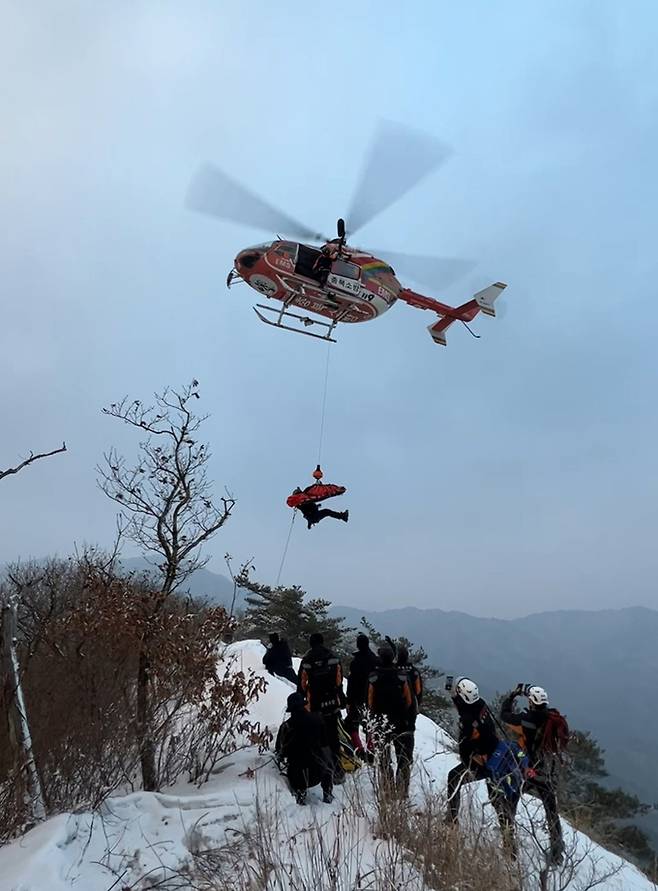 지난 7일 오후 1시45분쯤 경북 문경시 문경읍 상초리 조령산 신선암봉에서 50대 여성이 등반을 하다 미끄러지면서 중상을 입은 가운데 충북도소방헬기가 구조를 하고 있다. 경북도소방본부 제공