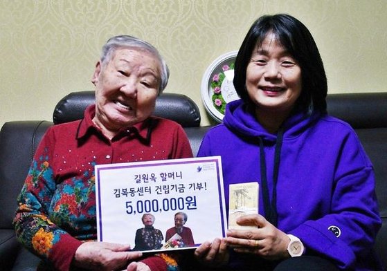 위안부 피해자 길원옥(95) 할머니가 2020년 1월 '김복동 센터' 건립 기금을 당시 윤미향 정의연 이사장(현 무소속 의원)에게 전달하는 모습. 길 할머니는 2017년 국민성금 1억원 중 5000만원을 정의연에 기부했지만 정의연 기부자 명단에 길 할머니는 없었다. 윤 의원은 횡령 등으로 재판을 받고 있다. 사진 김복동의 희망