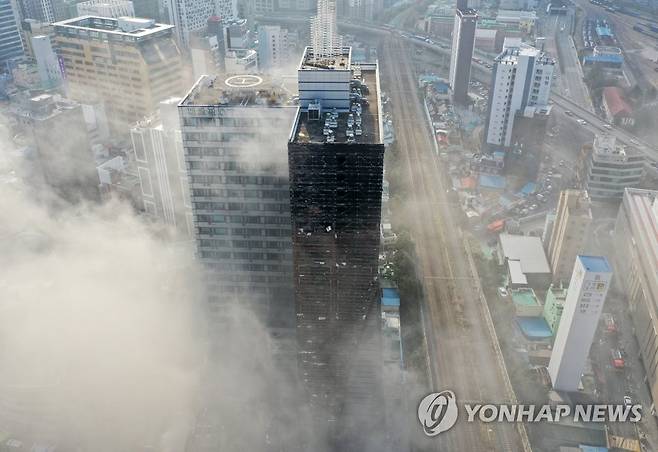 부산 도심 한복판 주차타워 화재 (부산=연합뉴스) 손형주 기자 = 9일 오전 부산진구 한 오피스텔 주차타워에서 불이 나 연기로 덮혀 있다. 불은 1시간여 만에 초진됐지만 인근 상가 건물로 번져 소방당국이 진화 중이다. 현재까지 연기흡입 외 중상자는 발생하지 않았다. 2023.1.9 handbrother@yna.co.kr