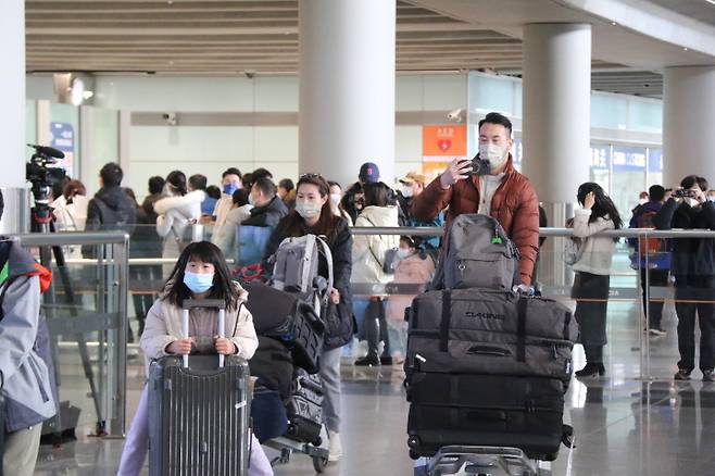 중국 강제격리 폐지 첫날인 8일 홍콩발 베이징행 항공편을 이용해 베이징 서우두 공항에 도착한 승객들이 입국장을 빠져나오고 있다. / 사진=연합뉴스