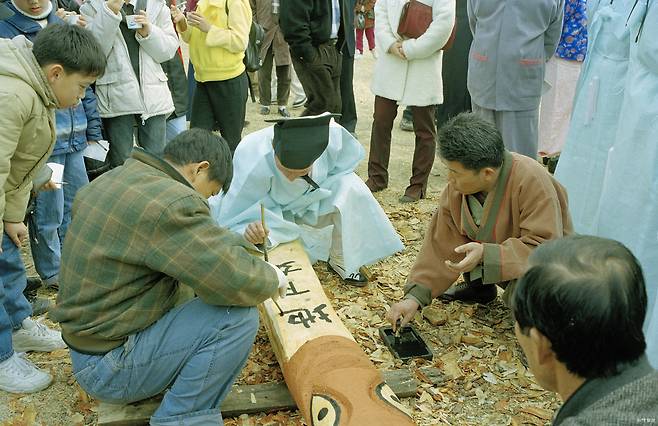 정월대보름 마을 수호신에게 지내는 ‘장승제’를 지내며 장승 위에 명문을 쓰는 모습. 국립민속박물관 제공
