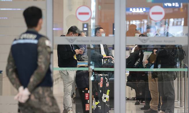 지난 9일 오전 인천국제공항 제2여객터미널로 입국한 중국발 입국자들이 입국장 게이트 안쪽에 모여있다. 연합뉴스