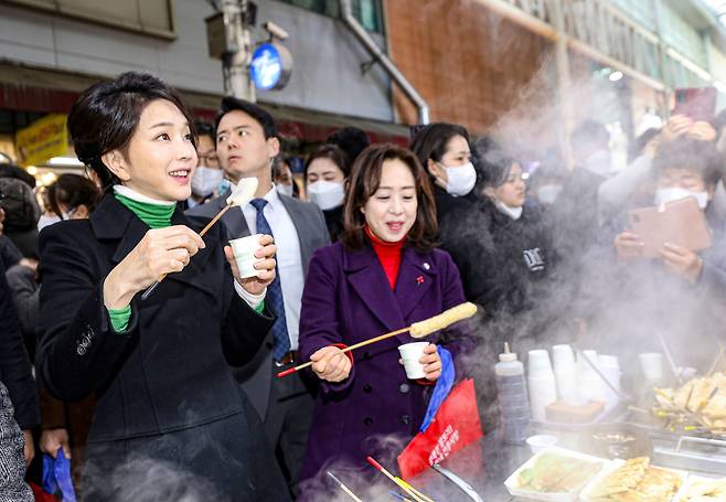 윤석열 대통령의 아내 김건희 여사가 11일 오후 대구 중구 서문시장을 찾아 어묵을 맛보며 상인과 이야기 나누고 있다. /뉴스1