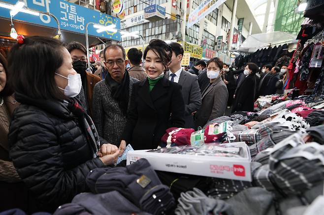 김건희 여사가 11일 대구 서문시장에서 급식 봉사를 했던 성서종합사회복지회 어르신들에게 전달할 양말 300켤레를 사고 있다. 대통령실 제공