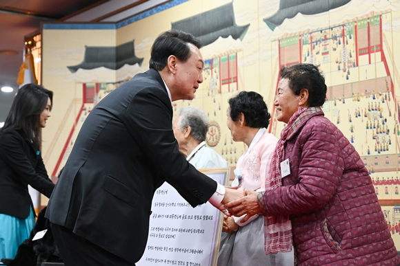 윤석열 대통령과 김건희 여사가 12일 오후 서울 용산 대통령실 청사에서 ‘칠곡할매글꼴’의 주인공인 칠곡 할머니들과 만나 인사를 나누고 있다. 2023.1.12 대통령실 제공