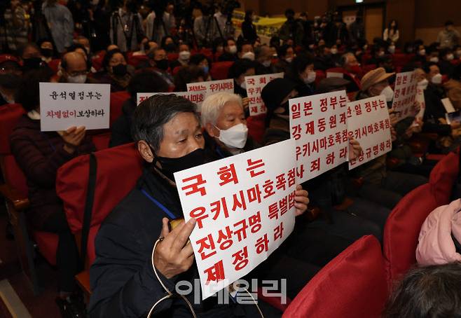 지난 12일 오전 서울 여의도 국회 의원회관에서 열린 강제징용 해법 논의를 위한 공개토론회에서 참석자들이 피켓을 들고 있다. (사진=노진환 기자)