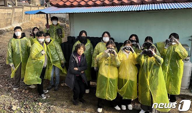 ‘동계 청소년 자원봉사학교’에 참가한 청소년들이 연탄 배달 후 사진을 찍고 있다. (계룡시 제공)