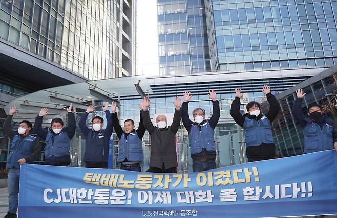 12일 서울행정법원은 CJ대한통운이 \"단체교섭 거부는 부당노동행위라는 재심 판정을 취소하라\"며 중앙노동위원회 위원장을 상대로 낸 소송을 원고 패소를 판결했다. 이날 민주노총 전국택배노조 진경호 위원장(오른쪽 세번째) 등이 법원 판결을 환영하는 포즈를 취하고 있다. 연합뉴스