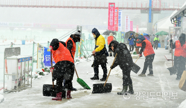 ▲ 화천군청 공무원들과 자원봉사센터 회원들은 15일 산천에축제장에 함박눈이 내리자, 통행로에 쌓인 눈을 치우고 있다.