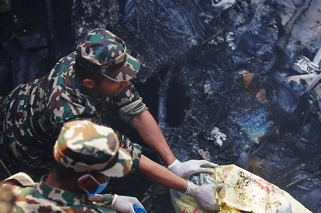 네팔 구조대원들이 15일(현지시간) 항공기 추락 사고 현장에서 구조 작업을 펼치고 있다. 연합뉴스