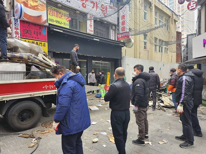 17일 오전 11시 50분쯤 서울 중구 명동의 한 골목에 쌓인 노점 철거 잔해물들을 공무원들과 현장 작업자들이 트럭에 옮겨 담고 있다. /이민준 기자