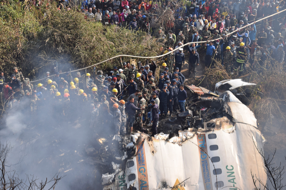 네팔 구조대원들과 민간인들이 지난 15일(현지시간) 네팔 포카라 추락 여객기 잔해 주위에 모여있다. 네팔 당국은 72명이 탑승한 여객기가 협곡에 추락, 68명이 사망한 것으로 확인됐다고 밝혔다. [사진=뉴시스]