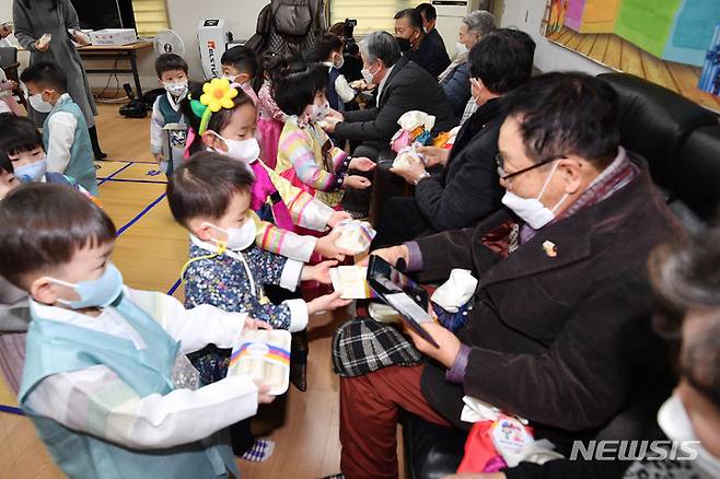 [서울=뉴시스] 조수정 기자 = 구립 삼성아트 어린이집 어린이들이 설 명절을 앞둔 17일 서울 송파구 문정 래미안 아파트 경로당을 찾아 합동 세배를 마친 뒤 어르신들께 떡을 전달하고 있다.  (공동취재사진) 2023.01.17. chocrystal@newsis.com