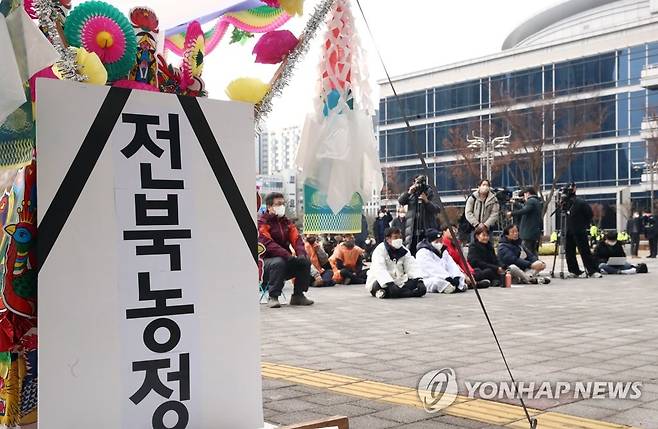 "전북도는 농민을 외면하지 마라" (전주=연합뉴스) 전국농민회총연맹(전농) 전북도연맹 등 농민단체가 지난해 12월 9일 오전 전북도청 앞에서 집회를 열고 "농민 생존권 대책을 마련하라"고 촉구했다. 집회 현장에 상여를 들고 전북도청사를 행진하는 퍼포먼스를 위한 상여가 놓여 있다. 2022.12.9 [연합뉴스 자료사진]