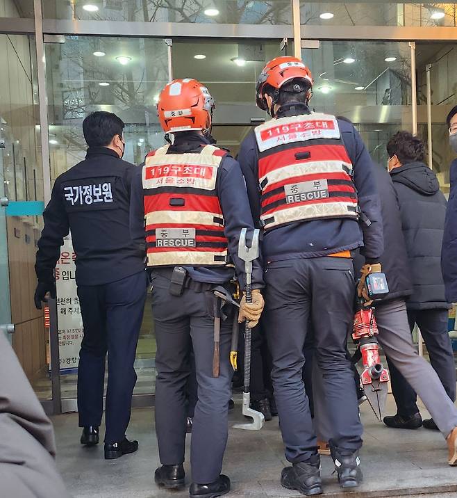 18일 오전 9시 국가정보원 수사관이 소방대원과 함께 서울 중구 민주노총 사무실이 있는 경향신문사 건물로 들어가고 있다. /이민준 기자