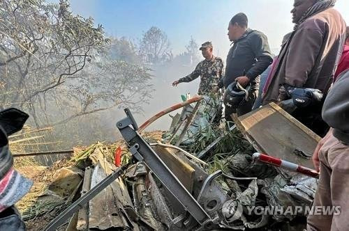 15일(현지시간) 예티 항공과 네팔 당국에 따르면 72명의 승객을 태운 네팔 예티 항공 소속 ATR72기가 추락했다. 사진은 이날 추락한 항공기 잔해가 남아있는 네팔 포카라에서 구조요원들이 모여 있는 모습. 연합뉴스