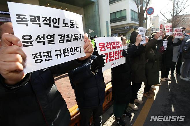 [서울=뉴시스] 조성우 기자 = 국정원이 민주노총에 대한 압수수색을 진행 중인 18일 오전 서울 중구 민주노총 앞에서 소속 조합원들이 피켓을 들고 규탄 구호를 외치고 있다. 2023.01.18. xconfind@newsis.com