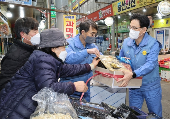 설을 앞두고 전통시장 장보기 행사에 참가한 이백희 포항제철소장이 17일 오전 경북 포항 해도동 큰동해시장을 찾아 떡과 건어물을 구매하고 있다.  포스코 제공